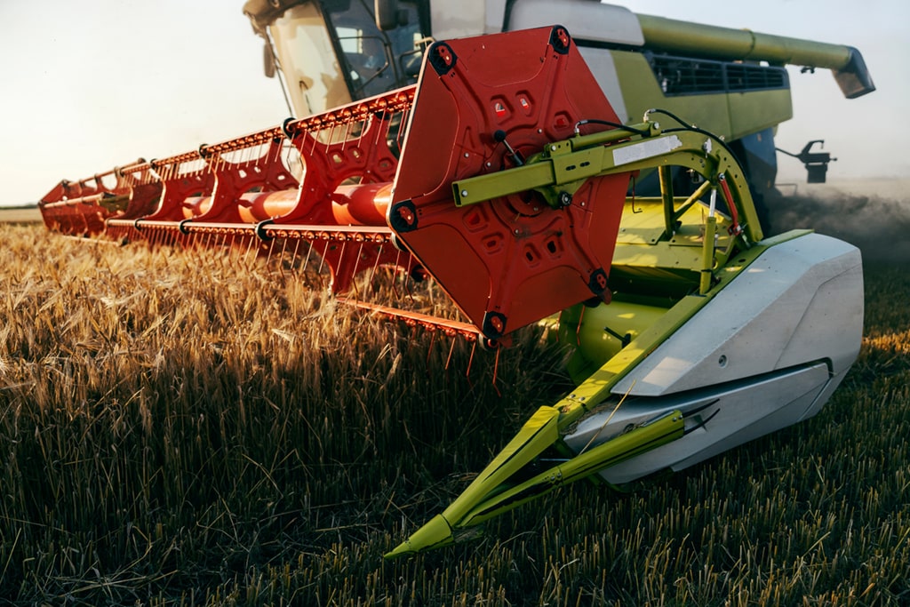 Modern combine harvester with a cutting header harvesting a wheat field.